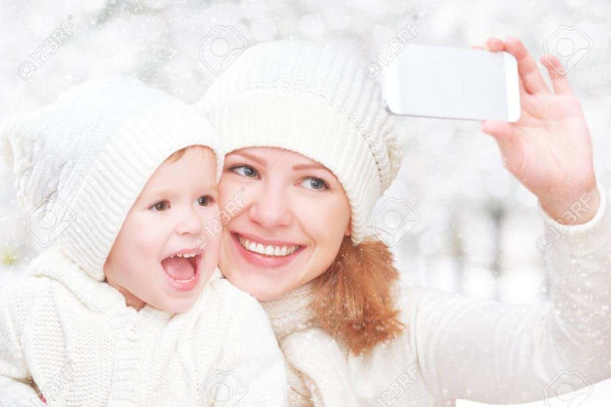 34572623-selfe-in-winter-happy-family-mother-with-baby-daughter-and-photographed-self-on-a-mobile-phone.jpg